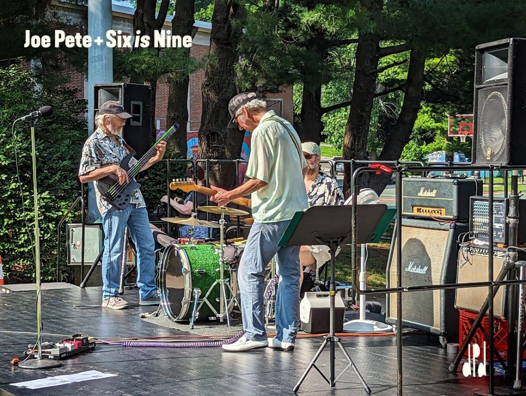 Photo of the band Joe Pete + Six is Nine playing an outdoor concert.